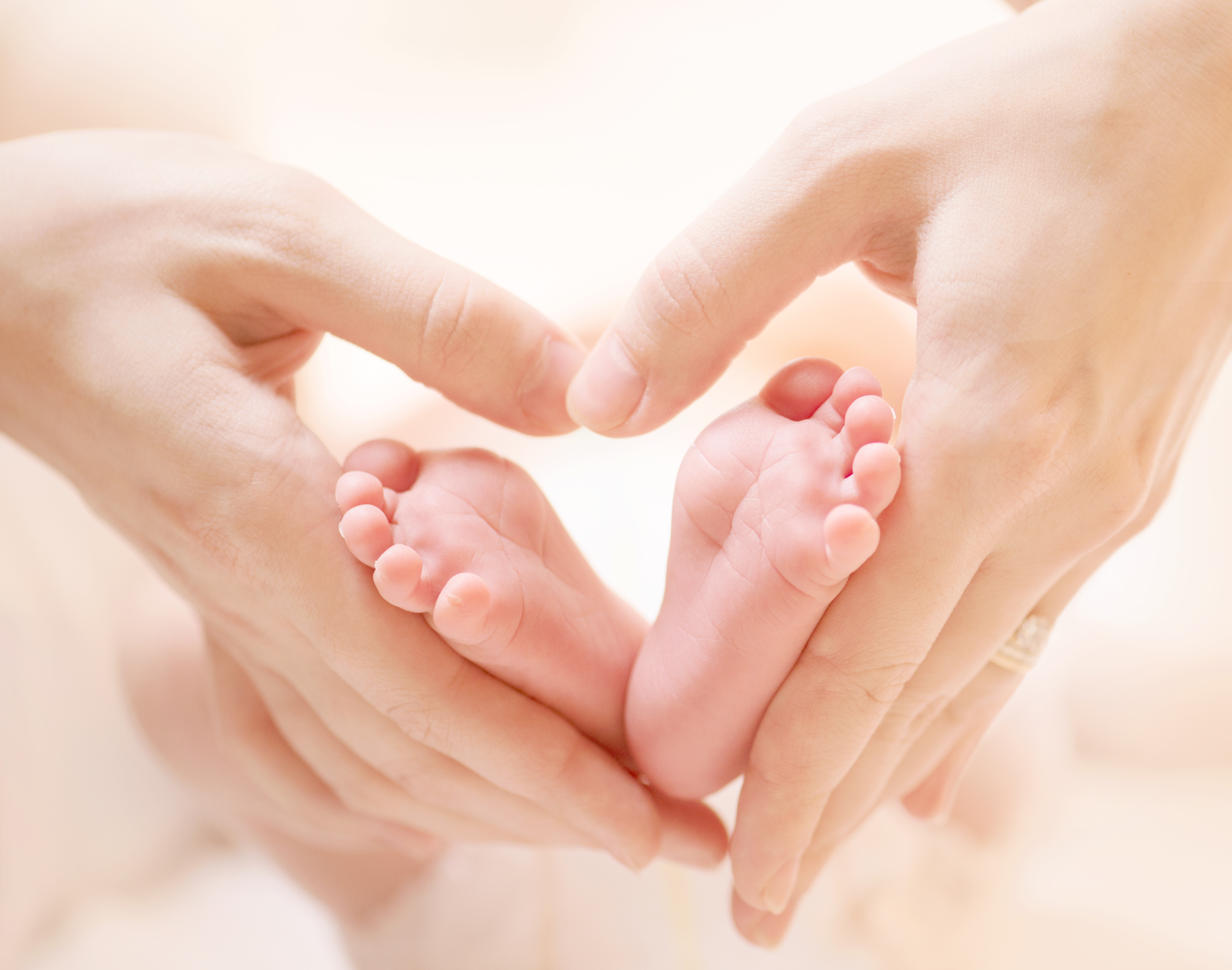 Baby feet in mother hands. Tiny Newborn Baby's feet on female He